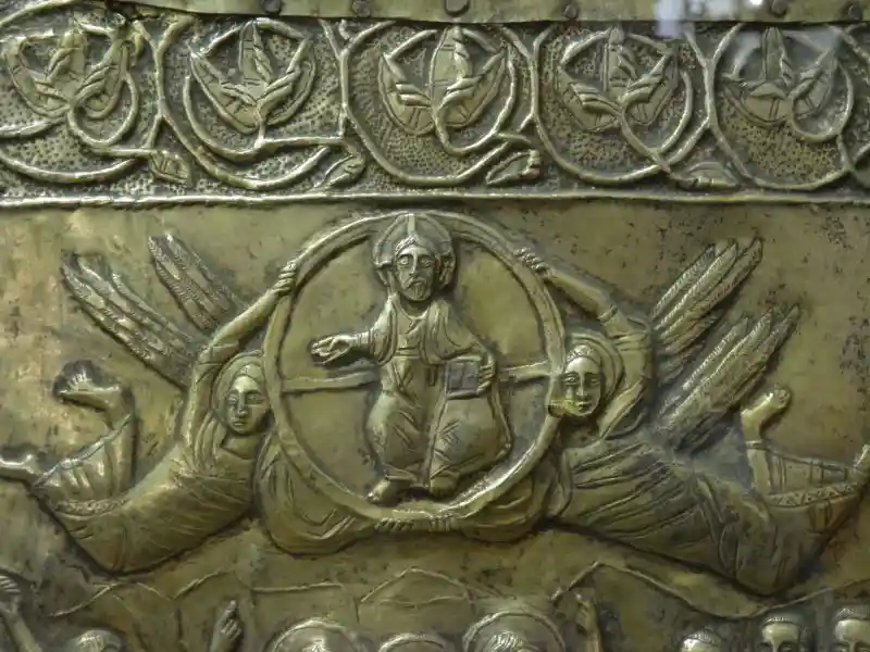 Jesus with halo inside a circle held by two angels